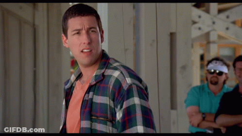 A Man In A Plaid Shirt Stands With His Arms Crossed In Front Of Two Other Men GIF