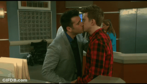 A Man In A Plaid Shirt Talks To A Man In A Suit GIF