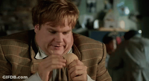 A Man In A Plaid Suit Is Eating A Hot Dog GIF