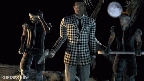 A Man In A Plaid Suit Stands Between Two Men GIF