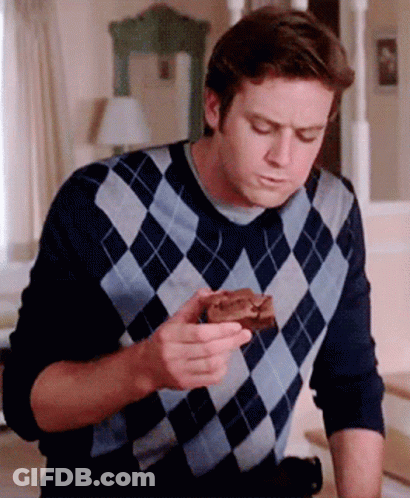 A Man In A Plaid Sweater Is Eating A Piece Of Chocolate Cake GIF