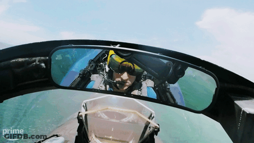 A Man In A Plane Is Reflected In A Rear View Mirror With The Word Prime On The Bottom GIF