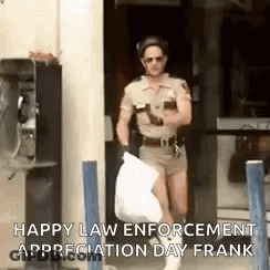 A Man In A Police Uniform Is Carrying A Trash Bag And A Cell Phone . GIF