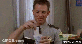 A Man In A Police Uniform Is Holding A Cup Of Ice Cream In His Hand . GIF