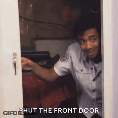 A Man In A Police Uniform Is Peeking Out Of A Door With The Words Shut The Front Door Below Him GIF