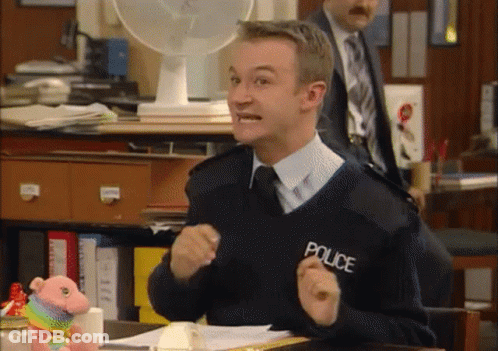 A Man In A Police Uniform Is Sitting At A Table GIF