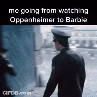 A Man In A Police Uniform Is Walking Down A Sidewalk Next To A Building . GIF