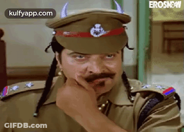 A Man In A Police Uniform Is Wearing A Hat With Horns On It And A Mustache . GIF