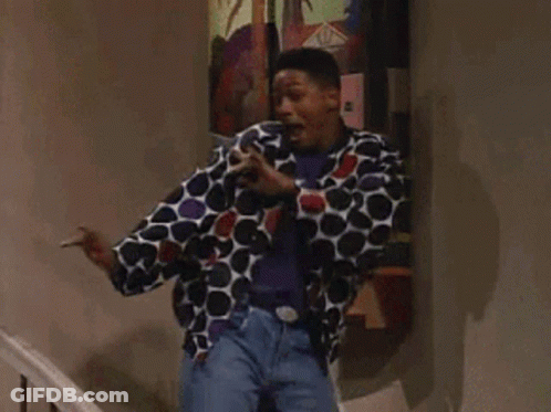 A Man In A Polka Dot Jacket Is Standing In Front Of A Painting GIF