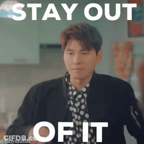 A Man In A Polka Dot Shirt Is Standing In Front Of A Sign That Says " Stay Out Of It " GIF