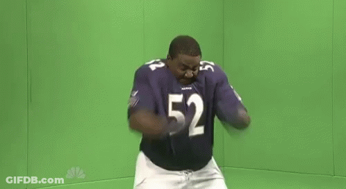 A Man In A Purple Football Uniform Is Dancing In Front Of A Green Screen . GIF