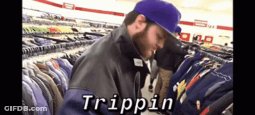 A Man In A Purple Hat Is Looking At Clothes In A Store And The Word Trippin Is On The Screen GIF