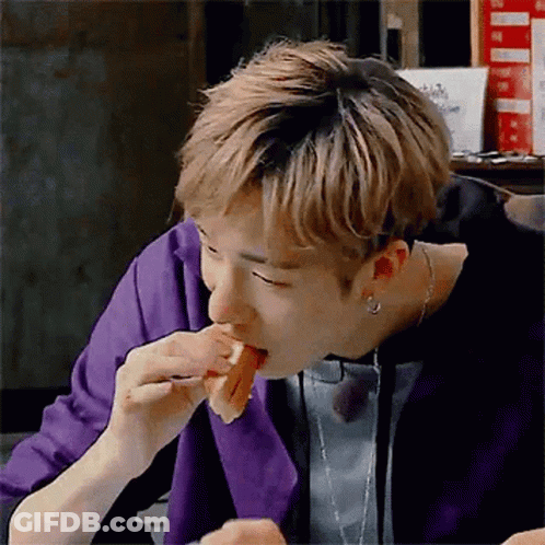 A Man In A Purple Jacket Is Eating A Sandwich With A Fork . GIF