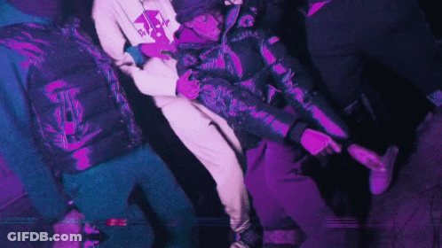 A Man In A Purple Jacket Is Holding Another Man GIF