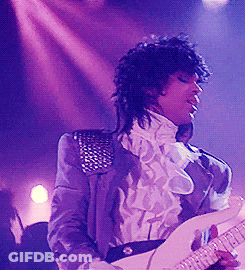 A Man In A Purple Jacket Is Playing A Guitar On A Stage GIF