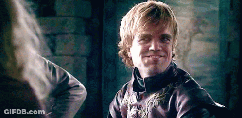 A Man In A Purple Jacket Is Smiling While Looking At Another Man . GIF