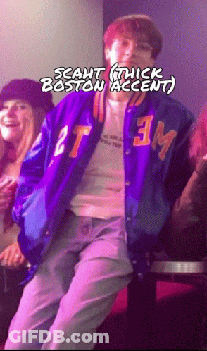 A Man In A Purple Jacket With The Letters Tm On It GIF