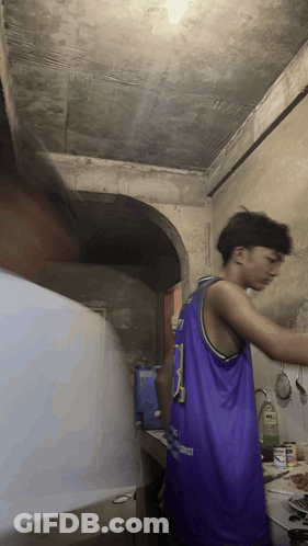 A Man In A Purple Jersey With The Number 3 On It Is Cooking In A Kitchen GIF