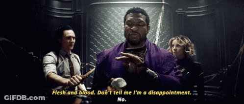 A Man In A Purple Robe Is Holding A Hammer And Talking To A Group Of People In A Dark Room . GIF