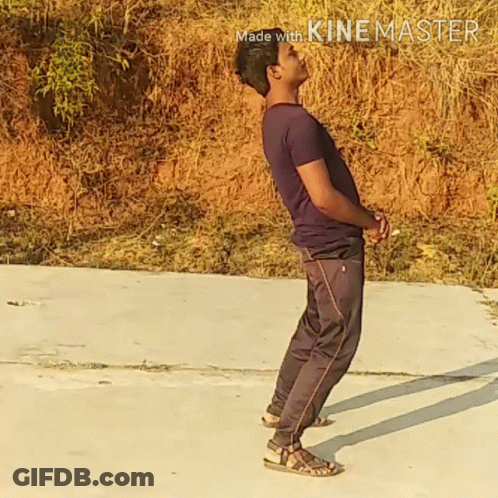 A Man In A Purple Shirt And Black Pants Is Standing On A Concrete Surface With The Words Made With Kinemaster In The Cor GIF