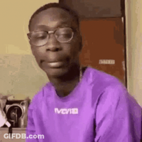 A Man In A Purple Shirt And Glasses Is Making A Funny Face . GIF