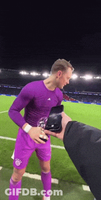 A Man In A Purple Shirt And Purple Shorts Holds A Trophy GIF
