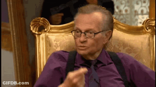 Man In Purple Shirt And Tie Sitting With Glasses GIF