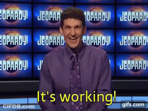 A Man In A Purple Shirt And Tie Says It 'S Working On A Jeopardy Show . GIF