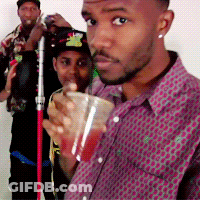 A Man In A Purple Shirt Holds A Cup Of Red Liquid GIF