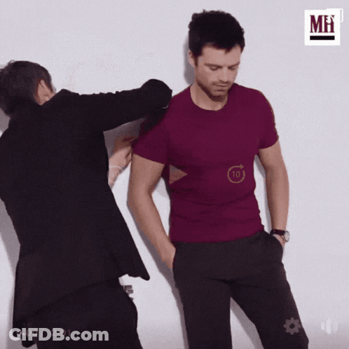 A Man In A Purple Shirt Is Being Touched By Another Man . GIF
