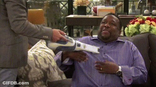 A Man In A Purple Shirt Is Being Vacuumed GIF