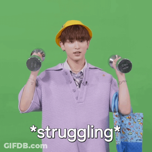 A Man In A Purple Shirt Is Holding A Dumbbell And A Blue Bag With The Words * Struggling * Written Below Him GIF