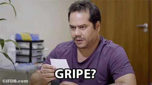 A Man In A Purple Shirt Is Holding A Piece Of Paper That Says " Gripe " GIF