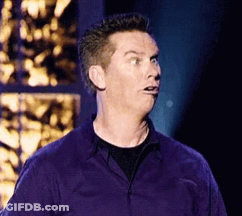 A Man In A Purple Shirt Is Making A Funny Face GIF