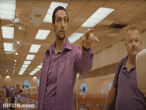 A Man In A Purple Shirt Is Pointing To Something GIF