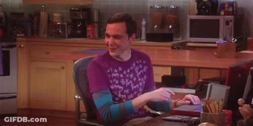 A Man In A Purple Shirt Is Sitting In A Chair In Front Of A Computer . GIF