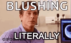 A Man In A Purple Shirt Is Sitting In Front Of A Computer Screen With The Words Blushing Literally . GIF