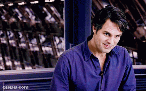 A Man In A Purple Shirt Is Sitting In Front Of A Window . GIF