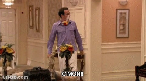 A Man In A Purple Shirt Is Standing In A Hallway And Says " C Mon " GIF