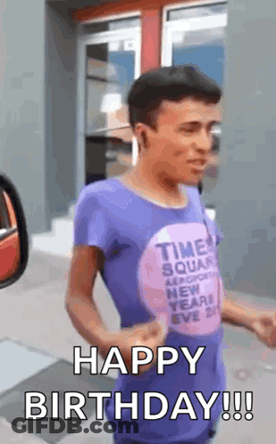 A Man In A Purple Shirt Is Standing In Front Of A Building And Says `` Happy Birthday '' . GIF