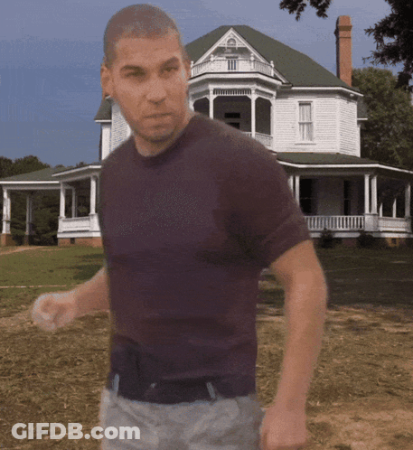 A Man In A Purple Shirt Is Standing In Front Of A White House GIF