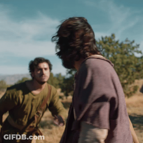A Man In A Purple Shirt Is Standing Next To Another Man GIF