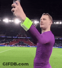 A Man In A Purple Shirt Is Taking A Picture Of Himself GIF
