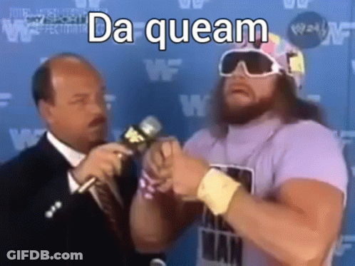 A Man In A Purple Shirt Is Talking Into A Microphone With A Man In A Suit Behind Him . GIF