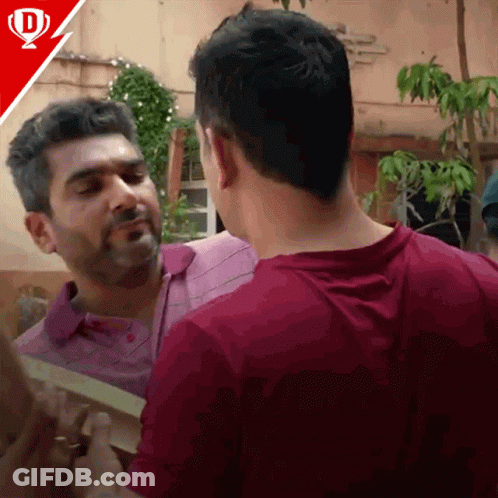 A Man In A Purple Shirt Is Talking To Another Man GIF