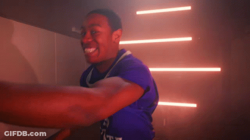 A Man In A Purple Shirt With The Word Duke On The Front GIF