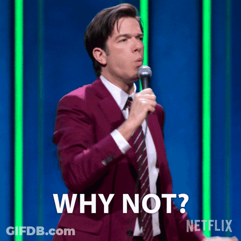 A Man In A Purple Suit And Tie Is Holding A Microphone And Says Why Not GIF