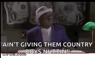 A Man In A Purple Suit And White Hat Is Sitting At A Desk In Front Of A Green Lamp . GIF