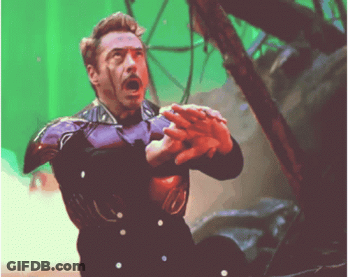 A Man In A Purple Suit Is Holding Something In His Hand GIF