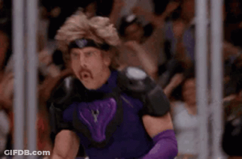 A Man In A Purple Superhero Costume Is Standing In Front Of A Crowd . GIF